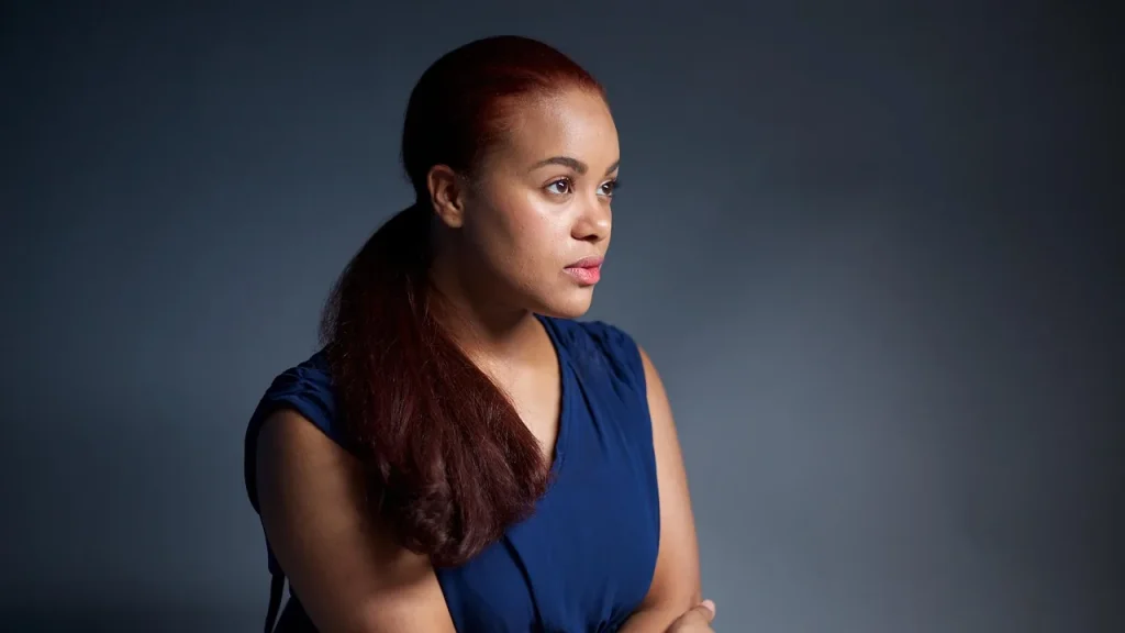 A woman brushing frizzy hair into a smooth, sleek look with a smoothing product.