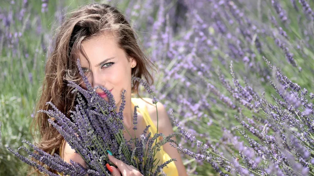 A jar of whipped lavender body butter beside fresh lavender sprigs.