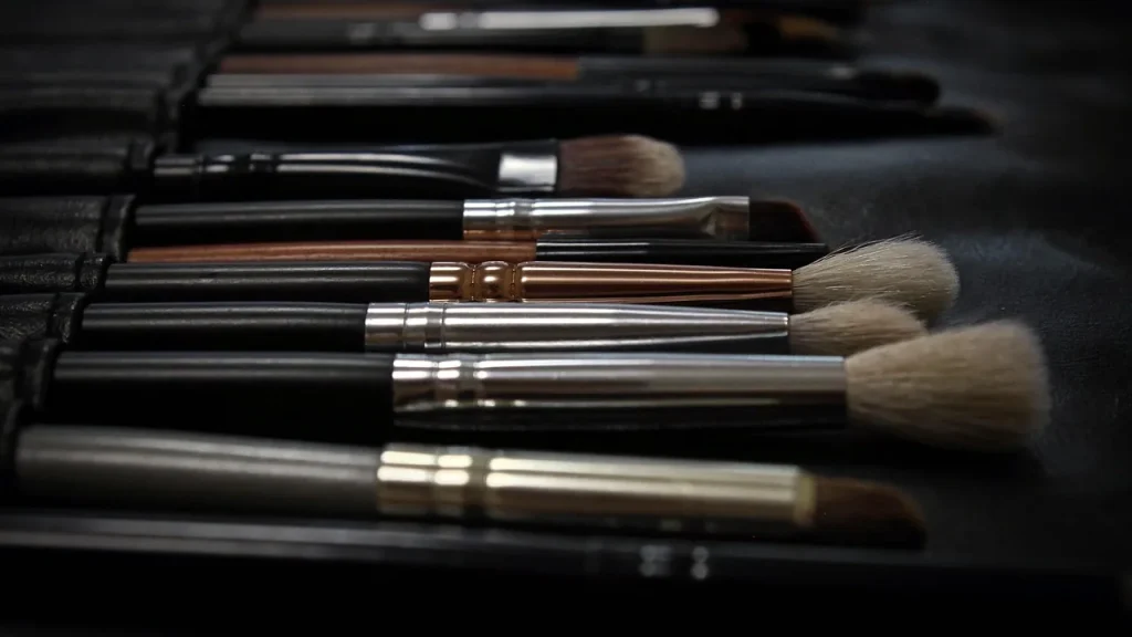 An assortment of affordable makeup products laid out on a vanity table.