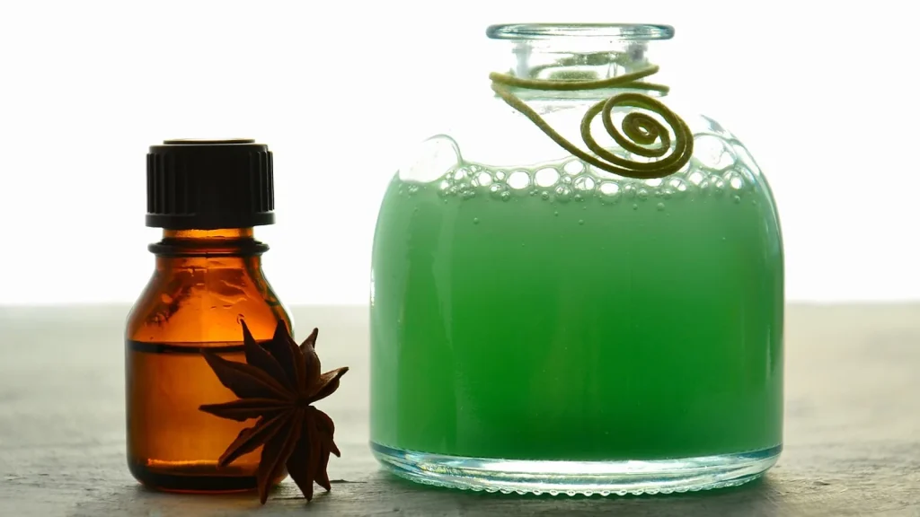 A woman smoothing a few drops of hair oil through the ends of her long shiny hair.
