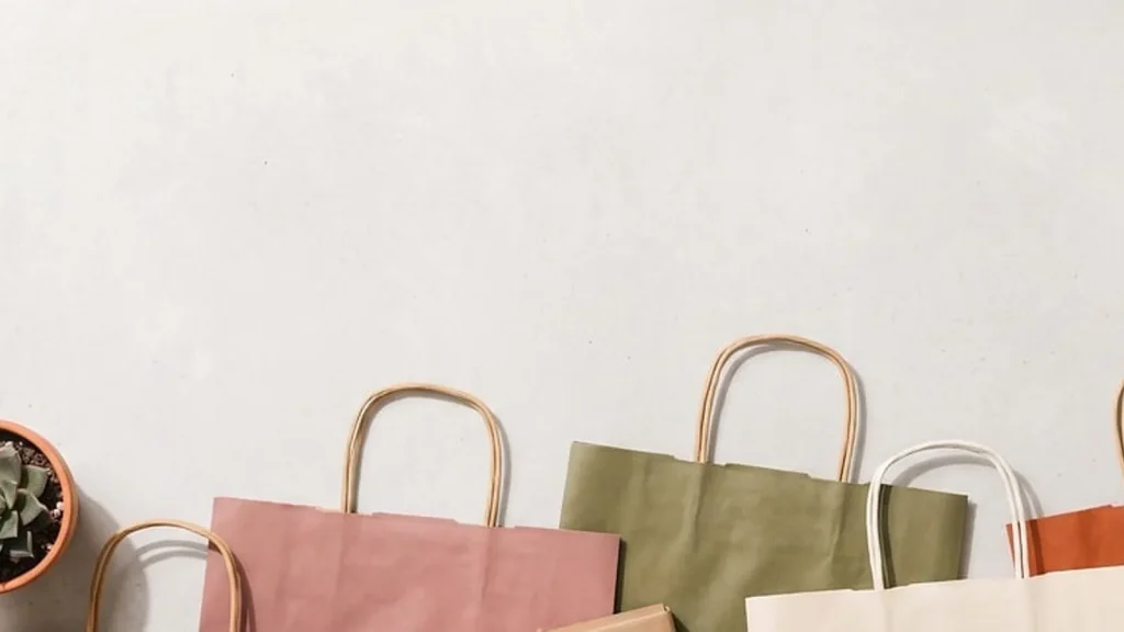 A reusable tote bag with vegetables in mesh produce bags and a reusable bottle.