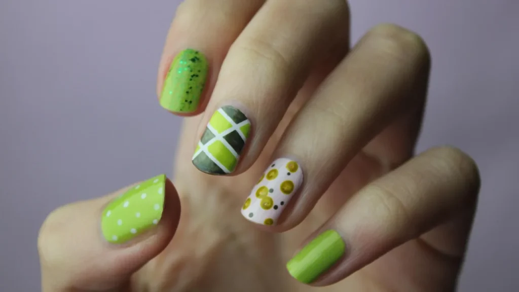 Well-groomed hands with natural nails receiving cuticle oil next to a tube of hand cream.
