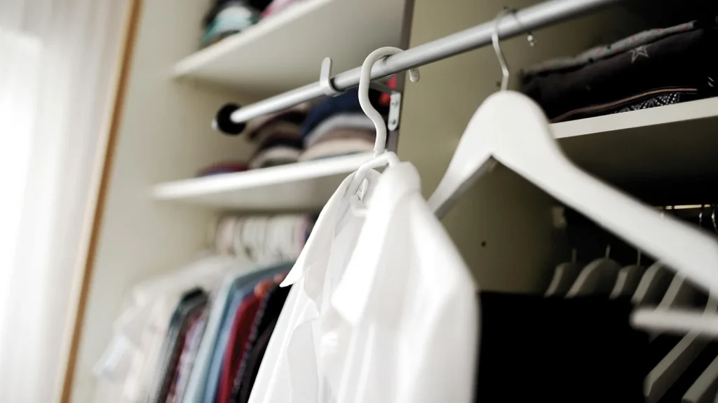 A clothing rack with a small, coordinated autumn capsule wardrobe in neutral tones.